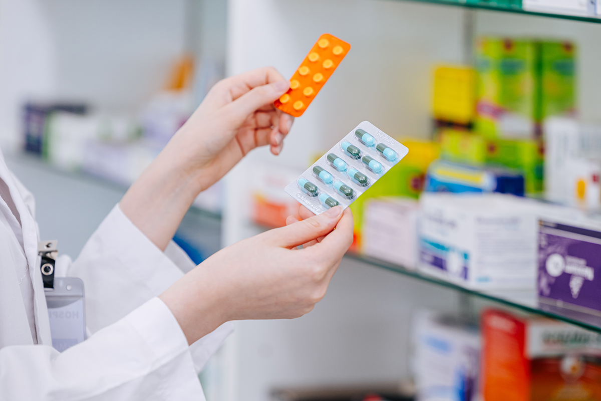Farmacist care tine in mana un amestec de medicamente de diferite tipuri in farmacie