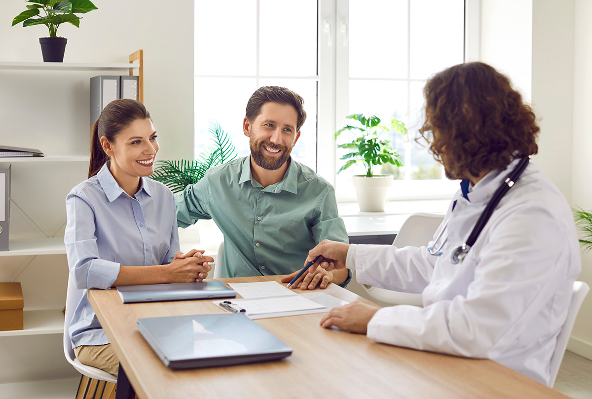 Cuplu discutand cu un medic despre screeningul genetic preconceptional