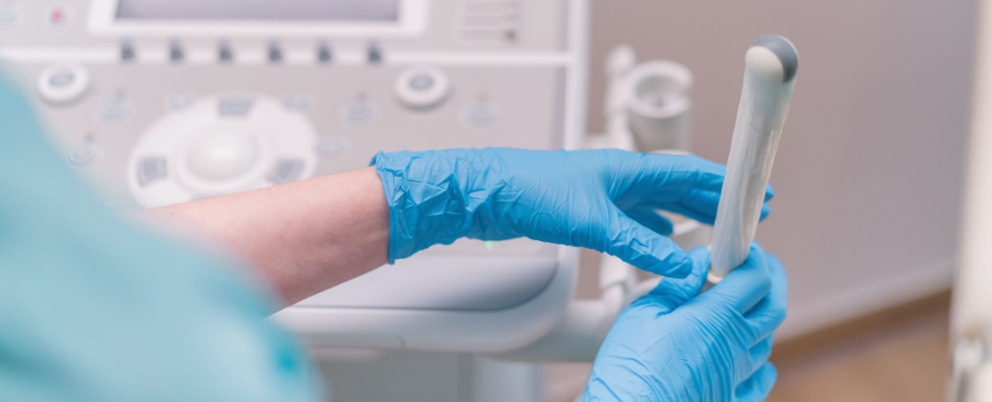Medic ginecolog tinand in mana o sonda pentru ecografie transvaginala