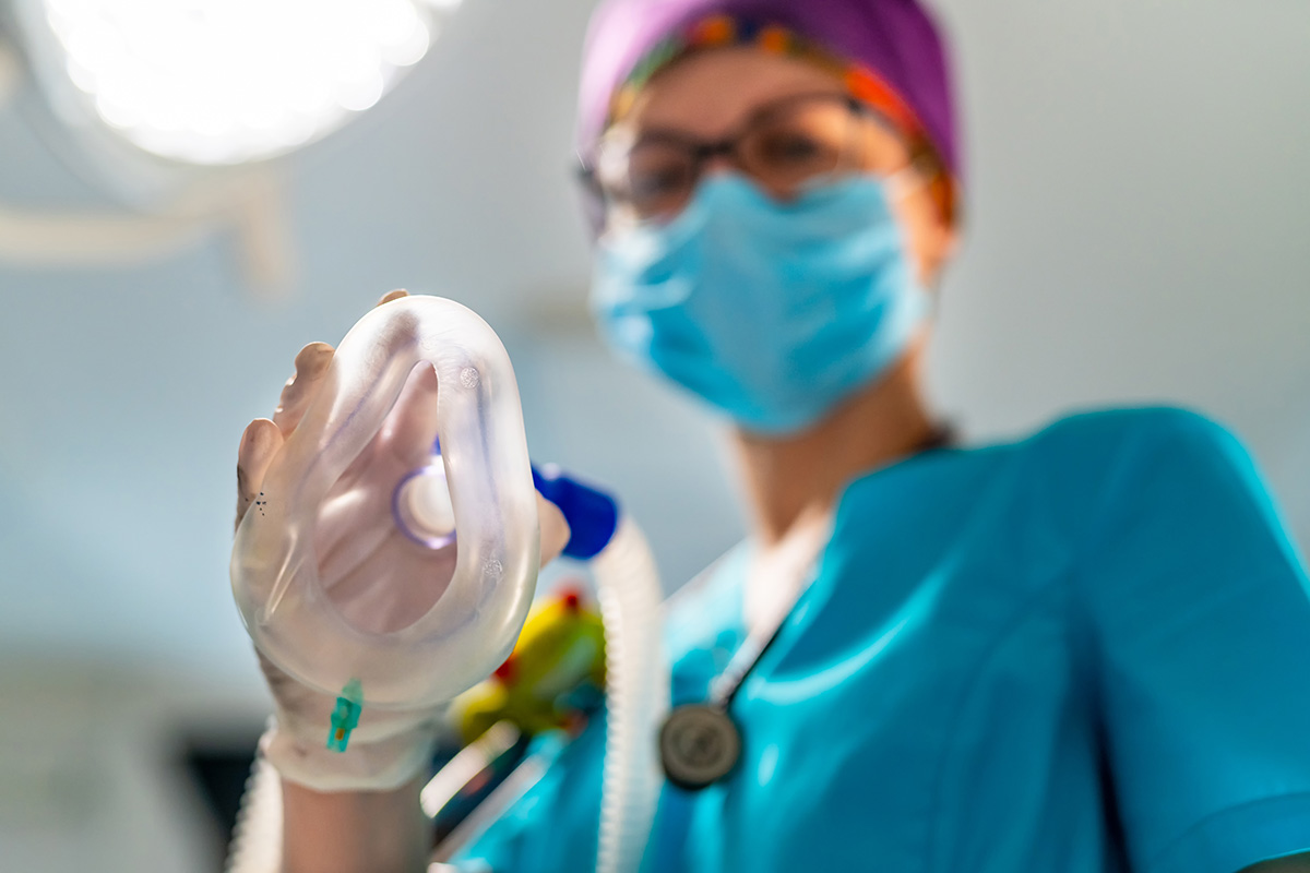 Medic inainte de interventie tinand o masca de anestezie