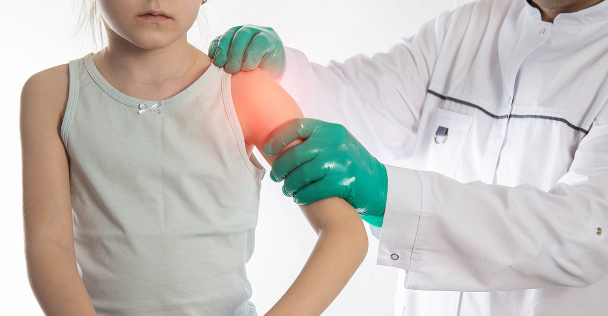 Medic ortoped examineaza umarul unei fetite