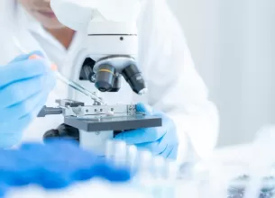 Specialist medical analizand o proba la microscop