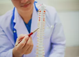 Medic explica stenoza pe un model anatomic coloana