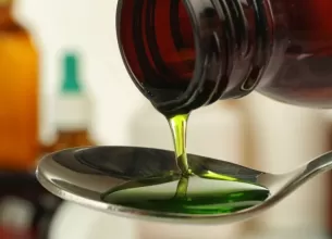Turnarea siropului de tuse intr-o lingura, ilustrand utilizarea acestuia ca tratament