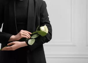 Femeie in doliu cu trandafir alb in maini