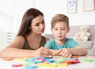 Mama vorbind si jucandu-se cu un copil cu autism