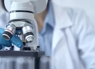 Prim plan cercetator folosind un microscop in laborator