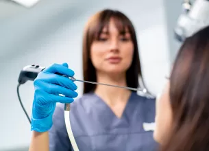 Prim-plan cu medic ORL care efectueaza o procedura de endoscopie nazala