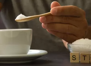 Barbat adauga zahar in cafea