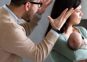 Barbat care tipa la o mama cu bebelusul in brate 