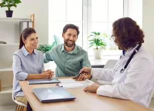 Cuplu discutand cu un medic despre screeningul genetic preconceptional