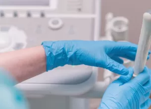 Medic ginecolog tinand in mana o sonda pentru ecografie transvaginala