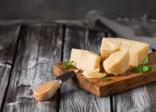 Bucati de parmezan pe un tocator din lemn