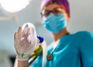 Medic inainte de interventie tinand o masca de anestezie