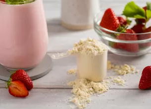 Pudra proteica langa un smoothie cu capsuni