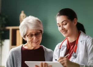 Doctorita si pacienta in varsta in cabinetul medical