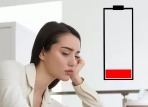 Ilustratie a unei femei epuizate la birou, simbolizand oboseala si lipsa de energie