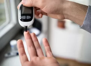 Barbat verificandu-si nivelul glicemiei acasa.