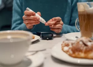 Femeie isi verifica nivelul glicemiei folosind un glucometru portabil