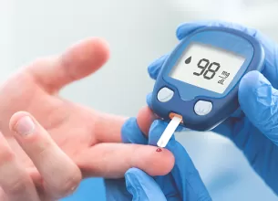 Medic efectueaza un test de glicemie pacientului in cadrul unei consultatii