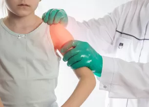 Medic ortoped examineaza umarul unei fetite