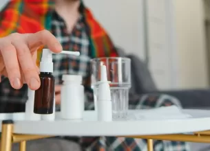 Barbat infasurat intr-o patura isi tine gatul din cauza durerii si racelii