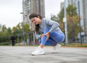 Femeie isi tine gamba din cauza unei dureri musculare