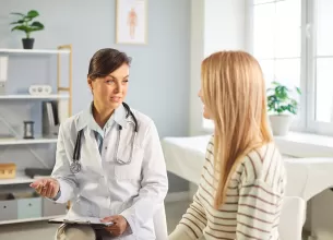 Medic si pacienta discutand despre terapia hormonala substitutiva in cabinet.