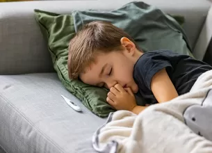 Copil bolnav, cu febra, care doarme