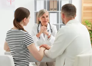 Cuplu la consultatie cu medicul despre fertilizarea in vitro (FIV)
