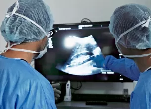 Echipa de chirurgi analizand o radiografie