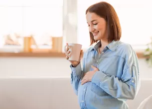 Femeie insarcinata bea o bautura calda in timpul sarcinii