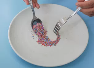 Fragmente de microplastic dispuse pe o farfurie si o lingura