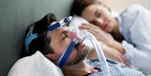 Barbat purtand aparat CPAP pentru apnee in somn