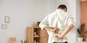 Barbat cu dureri de spate acasa.