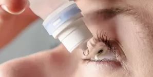 Femeie care isi administreaza lacrimi artificiale