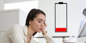 Ilustratie a unei femei epuizate la birou, simbolizand oboseala si lipsa de energie