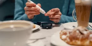 Femeie isi verifica nivelul glicemiei folosind un glucometru portabil