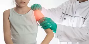 Medic ortoped examineaza umarul unei fetite