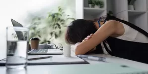 Tanara angajata surprinsa intr-un moment de oboseala la birou