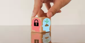 Cub de lemn cu imagini ce ilustreaza conceptul de reframing sau schimbare de perspectiva.