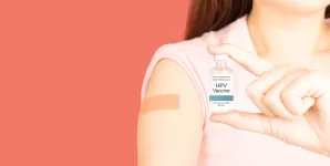 O femeie care tine in mana un flacon cu vaccin impotriva HPV
