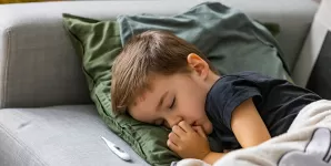 Copil bolnav, cu febra, care doarme