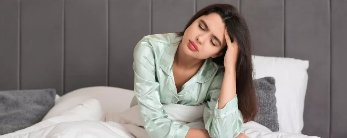 Femeie care se simte inca obosita dupa ce s-a trezit din somn