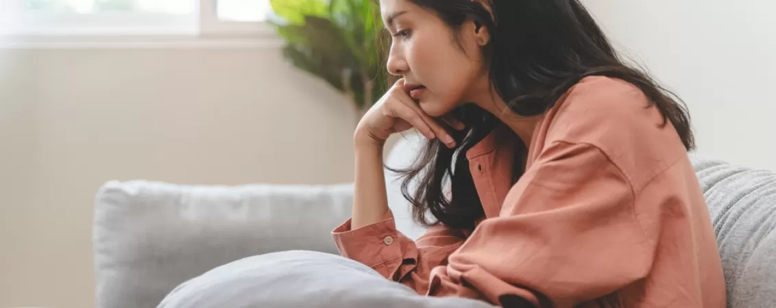 Femeie care sufera de sindromul cronic de oboseala post COVID-19 si sta pe o canapea