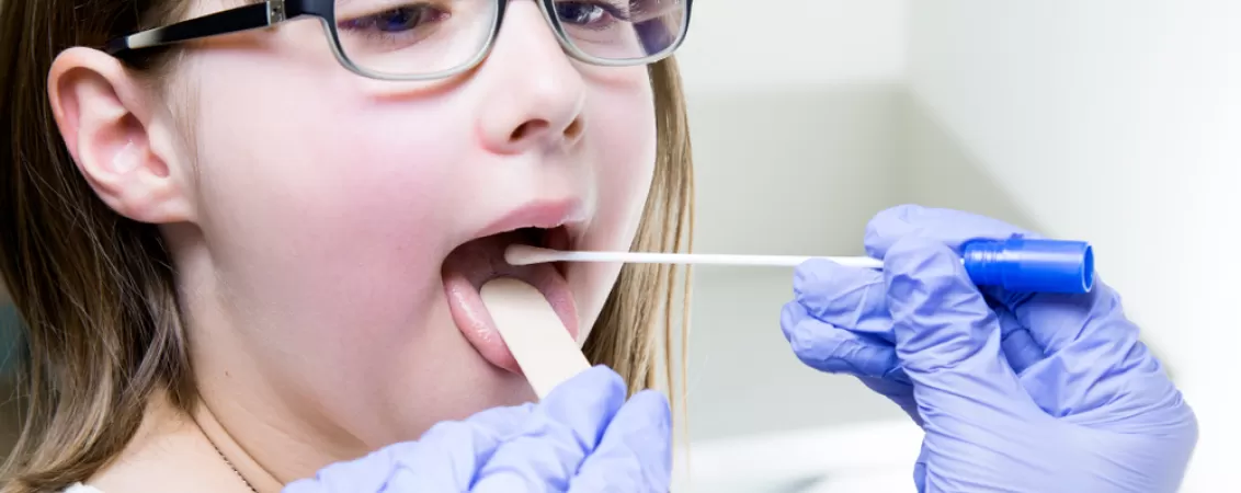 Medicul laringolog foloseste o spatula pentru a examina gatul unei fetite