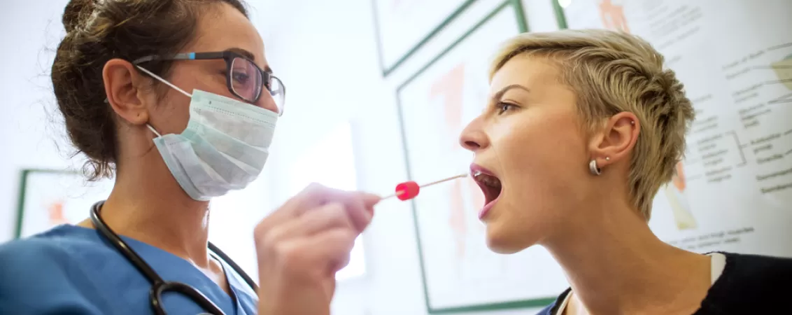 Vedere laterala a unui medic specialist femeie efectuand o examinare medicala