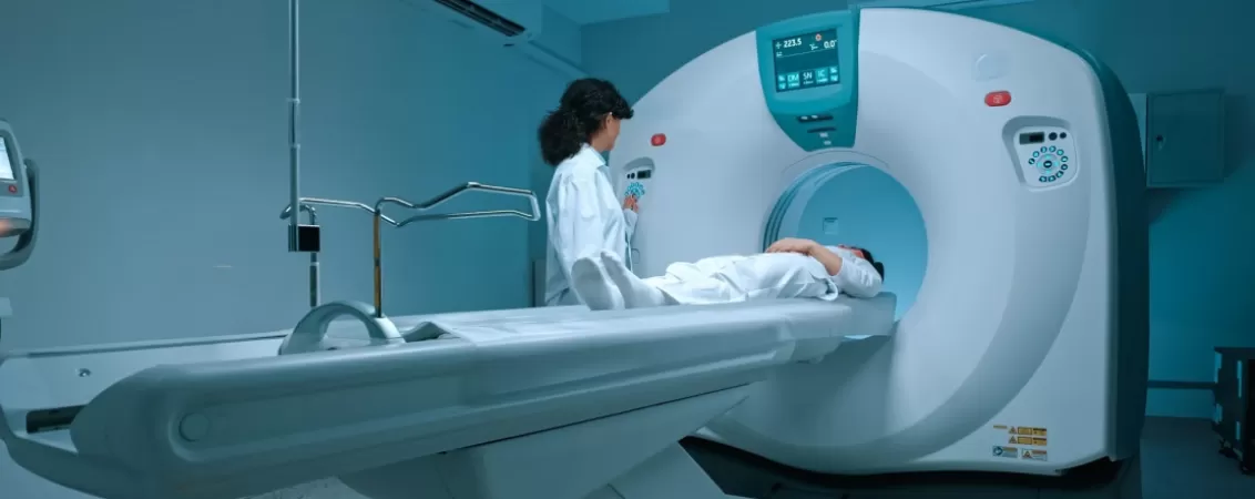 Pacient in haine albe efectuand un test de rezonanta magnetica (RMN)