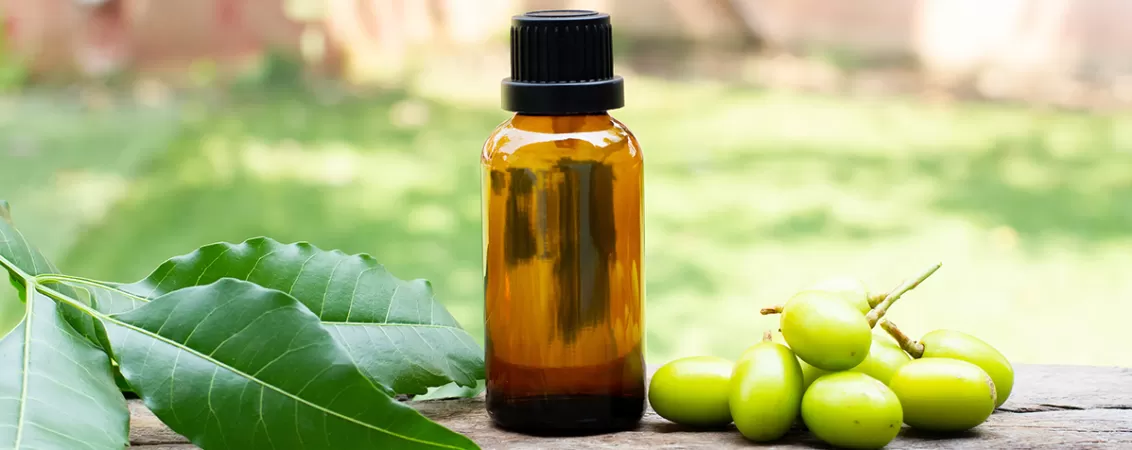 Sticluta cu ulei de neem pe o masa de lemn