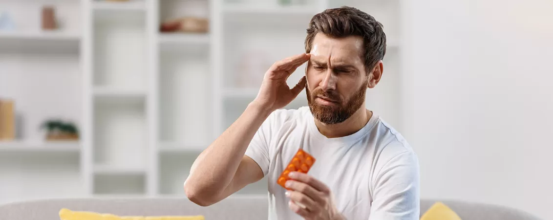 Barbat luand medicamente pentru durere de cap